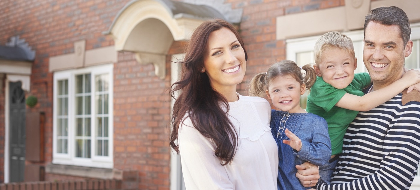 Family of four smiling in their front yard after receiving pediatric dental services in Dublin