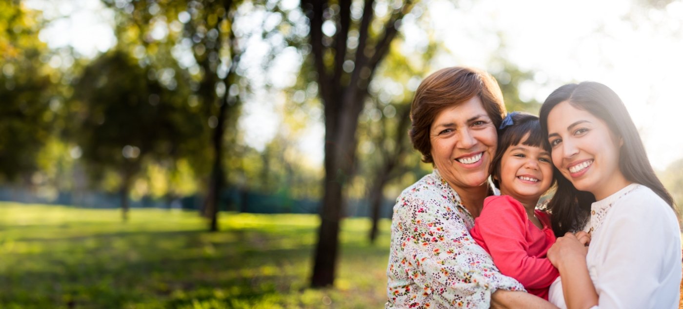 Grandmother mother and daughter smiling outdoors
