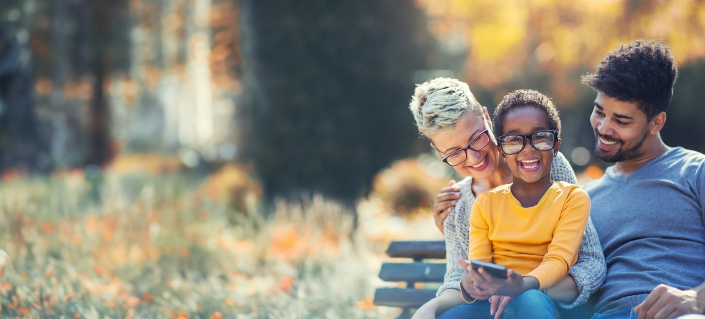 Mother father and child smiling on park bench after visiting childrens dentist in Dublin