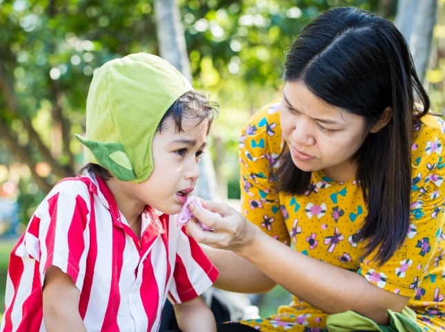 Mother holding washcloth to childs bleeding lip