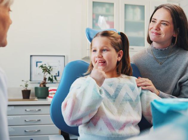 Mother and daughter talking to pediatric dentist