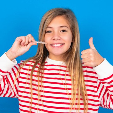 Pleased teen girl presents Invisalign tray