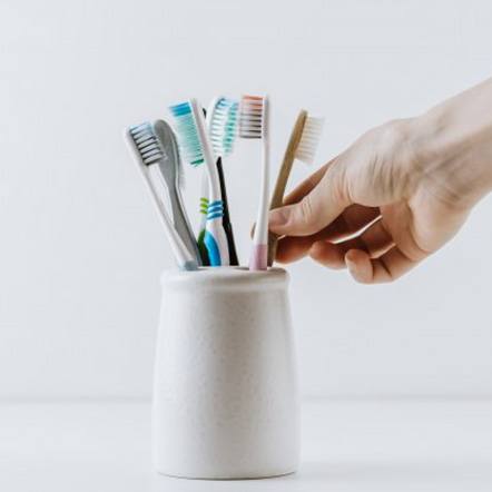 Hand reaches for toothbrush