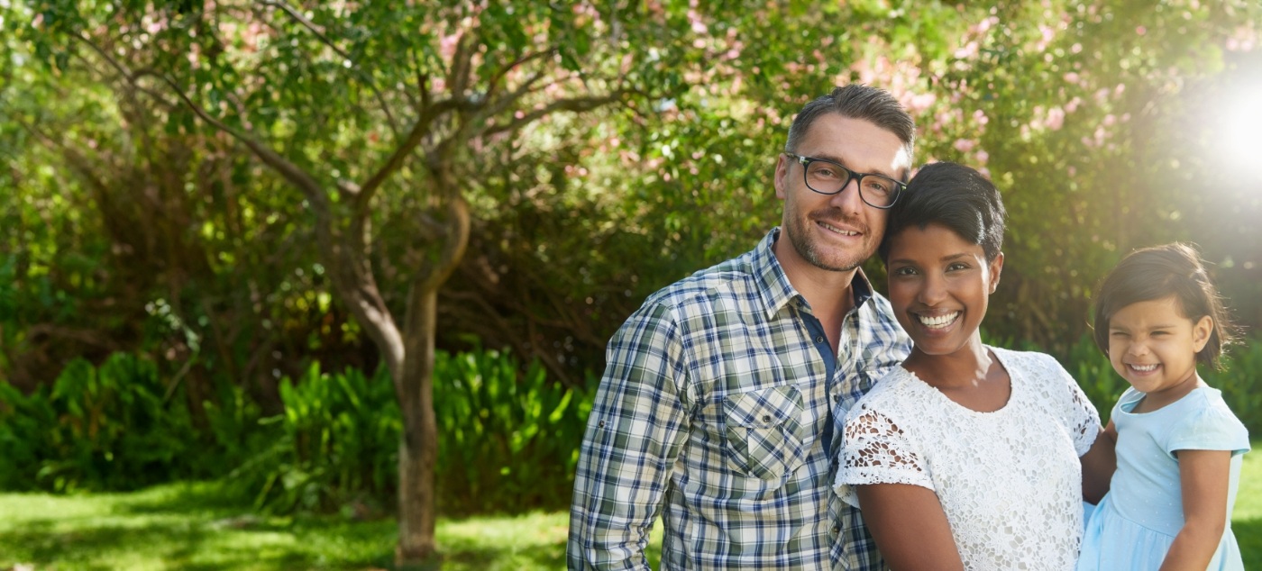 Family of three smiling outdoors after visiting pediatric dental office in Dublin
