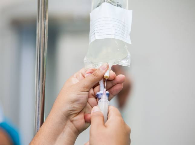 Person adjusting an I V drip