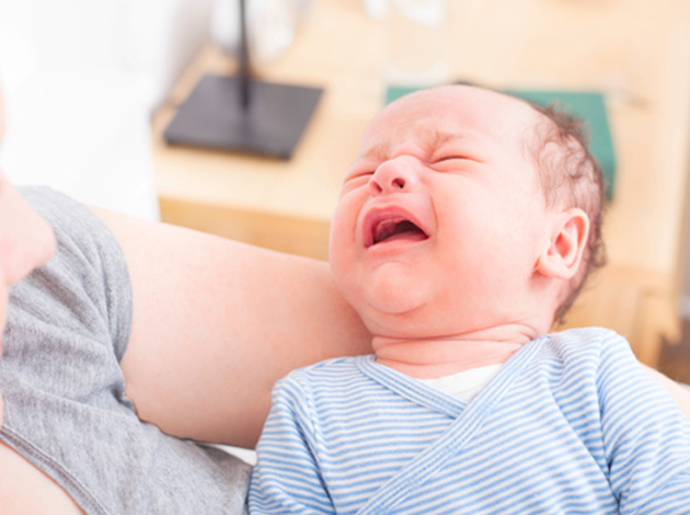 Fussy baby in their mother’s arms